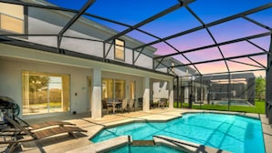 Ein modernes Haus mit einer großen Glasveranda, einem Schwimmbad und einem überdachten Außenbereich mit Möbeln.