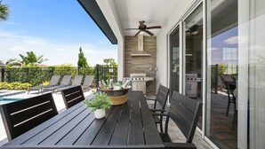 A patio with a table, chairs, a grill, and a ceiling fan. - Entire Home in Four Corners Florida Reu101 (Kissimmee)