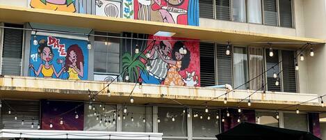 Un edificio de varios pisos con murales coloridos en la fachada.