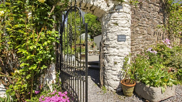 Un arco de piedra que da acceso a un edificio con la inscripción "The Old Kitchen".