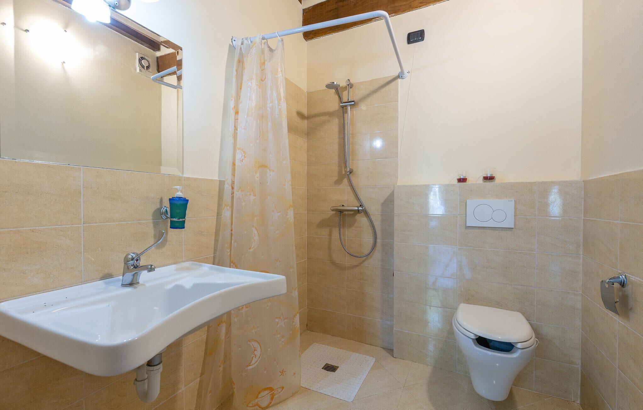 A bathroom with a shower, toilet, and sink.