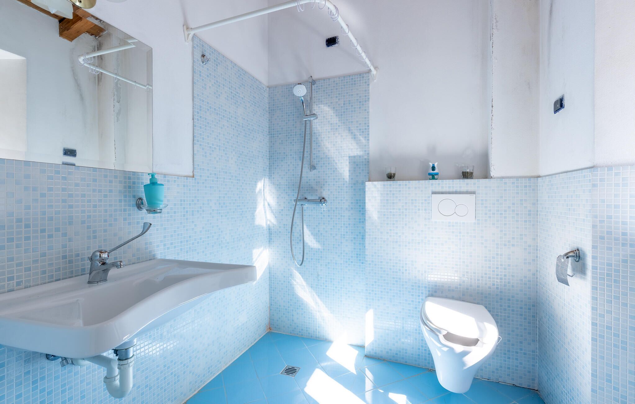 A bathroom with a sink, toilet, and shower.