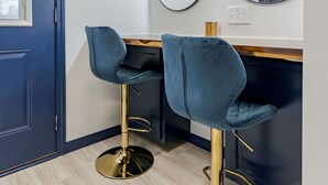 A room with two blue bar stools, a mirror with lights, and a door. - Sleek+ Modern Home Close to Downtown (Elizabethtown)