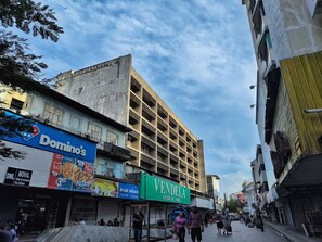 A street with various shops, including a Domino's Pizza store and a store named 'VENDELA'. - Ocre Studio By Paradox (Panama City)