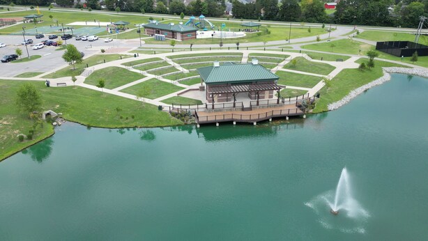 A lakeside building with a deck and a fountain.