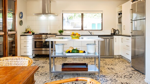 A modern kitchen with white cabinets, stainless steel appliances, a central island with a bowl of fruit, and patterned flooring. - Te Awanga-Zari House- Private&Quiet- 
Children & PETS welcome* (Upon agreement) (Te Awanga)
