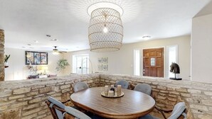 Un comedor con pared de piedra, una mesa de madera y seis sillas.