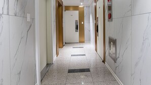 A hallway with marble walls and a tiled floor, leading to a door marked with the number 501. - Star Light (Seoul)