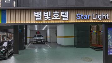 A parking garage entrance with a car in the foreground and a sign reading "Star Light".