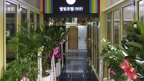 A hallway with a sign reading "Bel Air Hotel (Bel Air)" and potted plants on either side. - Star Light (Seoul)