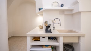 A compact kitchen with a sink, storage shelves, and a countertop. - GuestHost - La Mille - Charming Ostuni Apartment (Ostuni)
