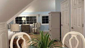 A dining area with a table set for four, a potted plant in the center, and a view of a bedroom with a bed and dresser in the background.