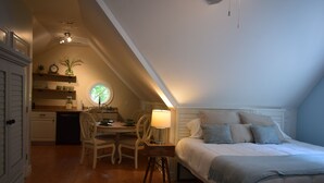 A bedroom with a bed, bedside table, lamp, and a window.