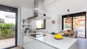 A modern kitchen with a large island, built-in appliances, and a dining area with a view.