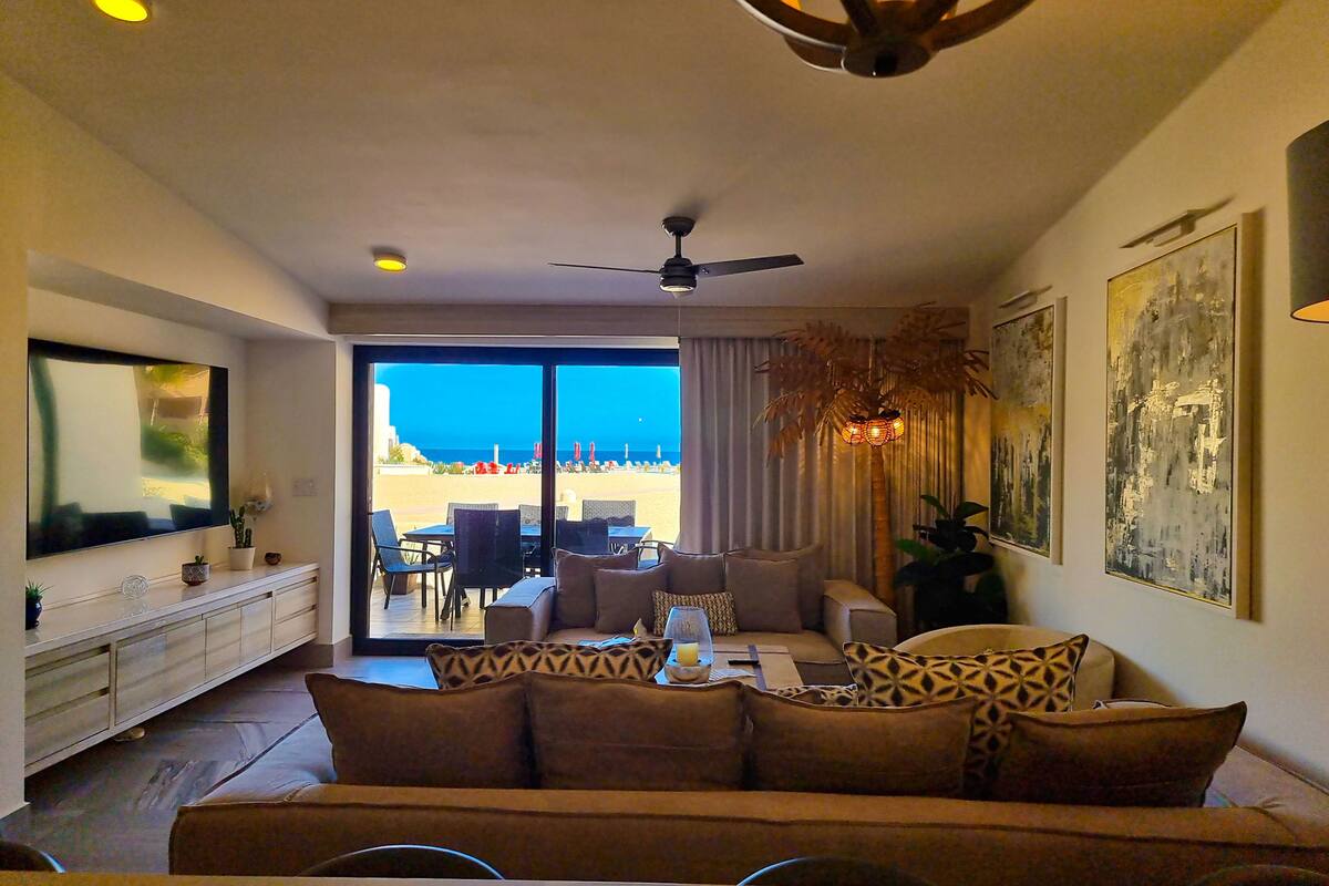 Una sala de estar con sofá, comedor y vista a la playa.