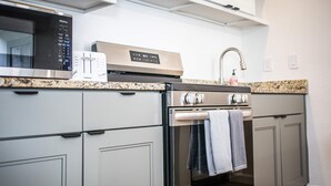A kitchen with a stainless steel microwave, a built-in oven, and a granite countertop.