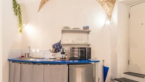A compact kitchen with a blue countertop, a built-in microwave, and a small refrigerator. - Studio in the centre with A/C and WiFi | Ap54 (Imperia)