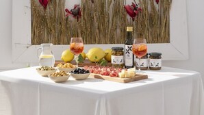 A table with a variety of food items including cheeses, olives, and cured meats, along with bottles of wine and a pitcher of water. - Studio in the centre with A/C and WiFi | Ap54 (Imperia)