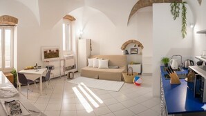 A modern, well-lit room with a sofa, dining table, and kitchen area. - Studio in the centre with A/C and WiFi | Ap54 (Imperia)