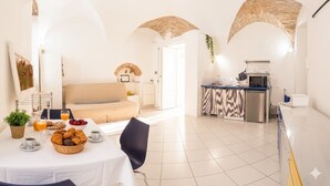 A bright, open-plan living area with a sofa, dining table, and kitchen. - Studio in the centre with A/C and WiFi | Ap54 (Imperia)