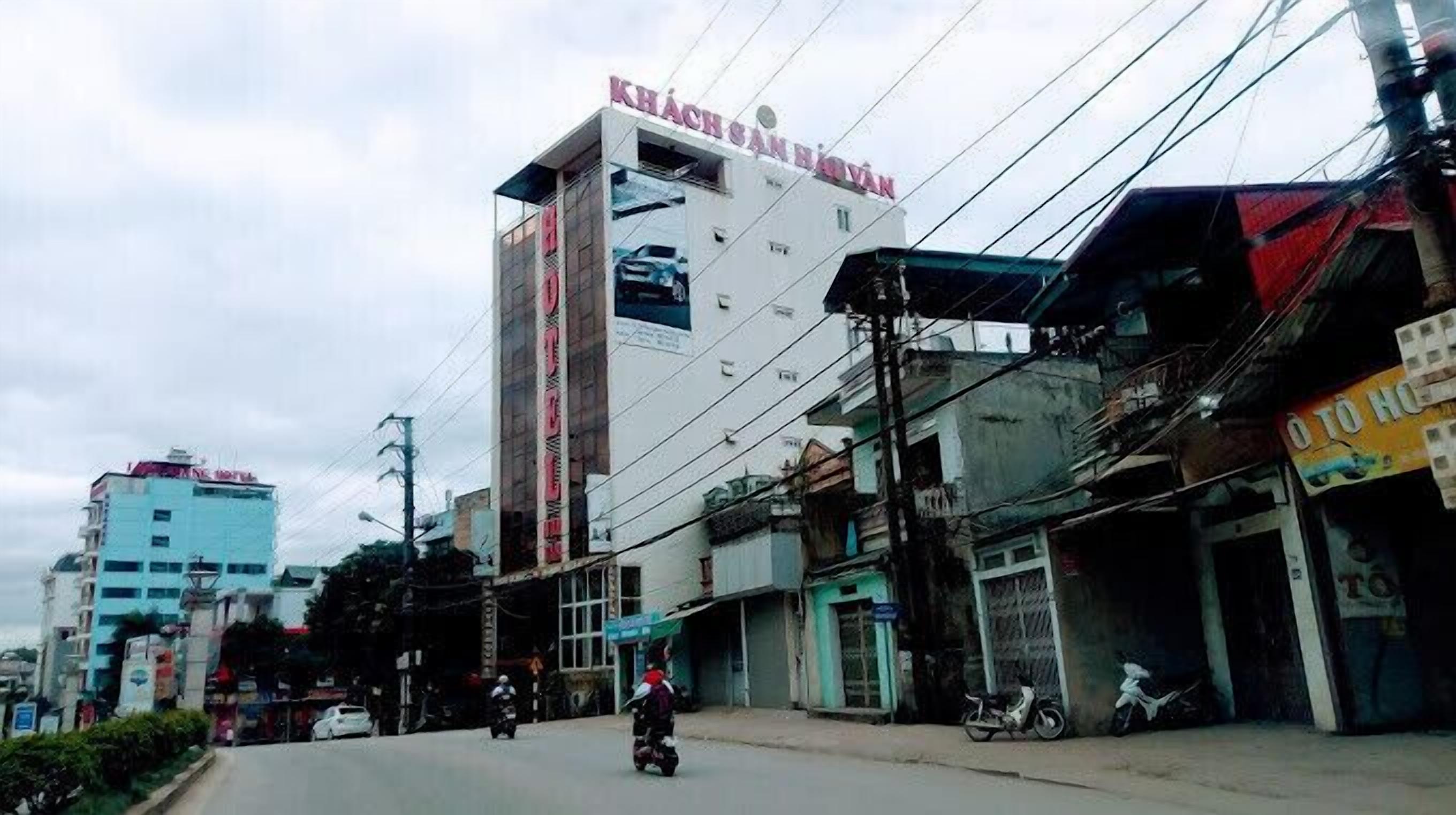 A multi-story building with a prominent sign reading "KHÁCH SÀN HỮNH".
