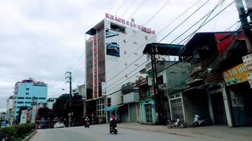 A multi-story building with a prominent sign reading "KHÁCH SÀN HỮNH".