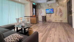 Een moderne woonkamer met een bank, een salontafel en een tv aan de muur.