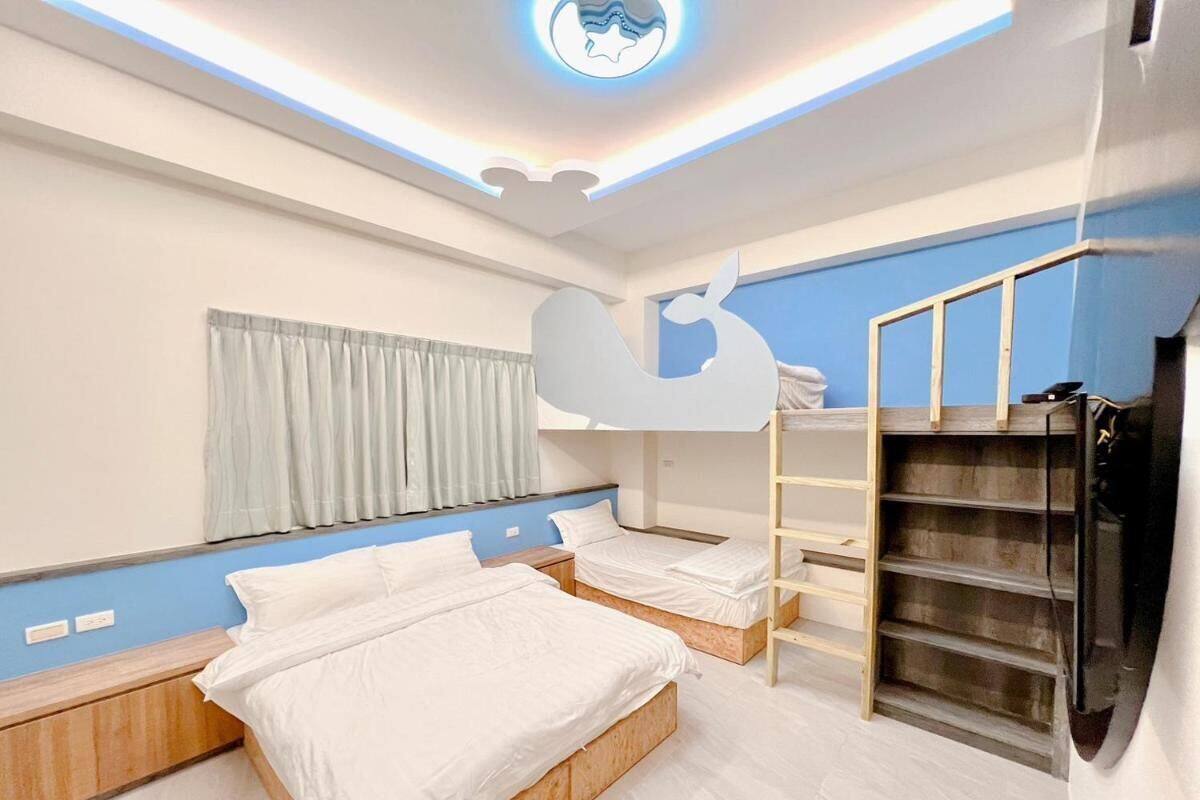 Un dormitorio con dos camas, una litera, un armario y un televisor.