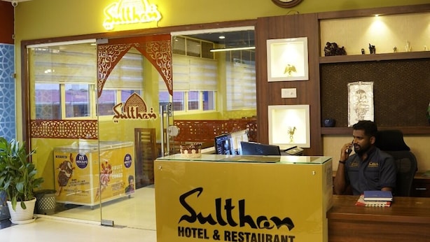 Der Empfangsbereich des Sulthan Hotel & Restaurant mit einem Schachbrettmuster-Boden, einem Empfangstresen und einer Uhr an der Wand.