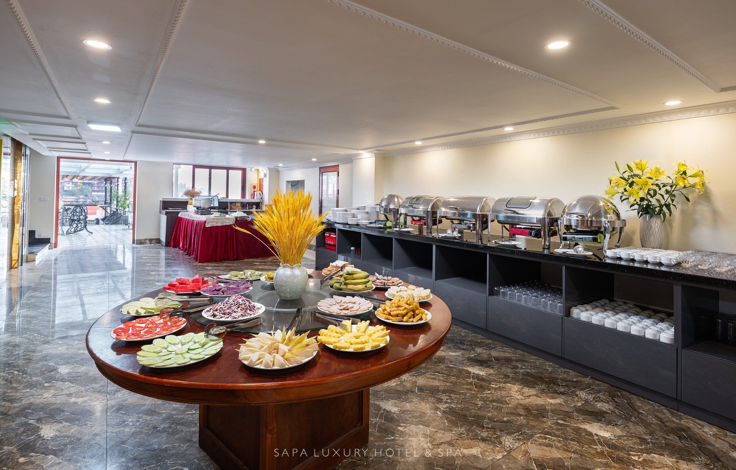 A buffet setup with various food items and a coffee station in a hotel setting.