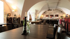 A restaurant with a stone wall, wooden tables, and chairs. - Apartment 'Bioweingut Hauerhof 99 -1' with Shared Garden, Wi-Fi and Air Conditioning (Klosterneuburg)