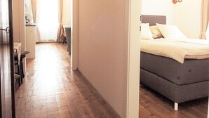 Un pasillo que conduce a un dormitorio con una cama, un comedor y vistas al exterior.