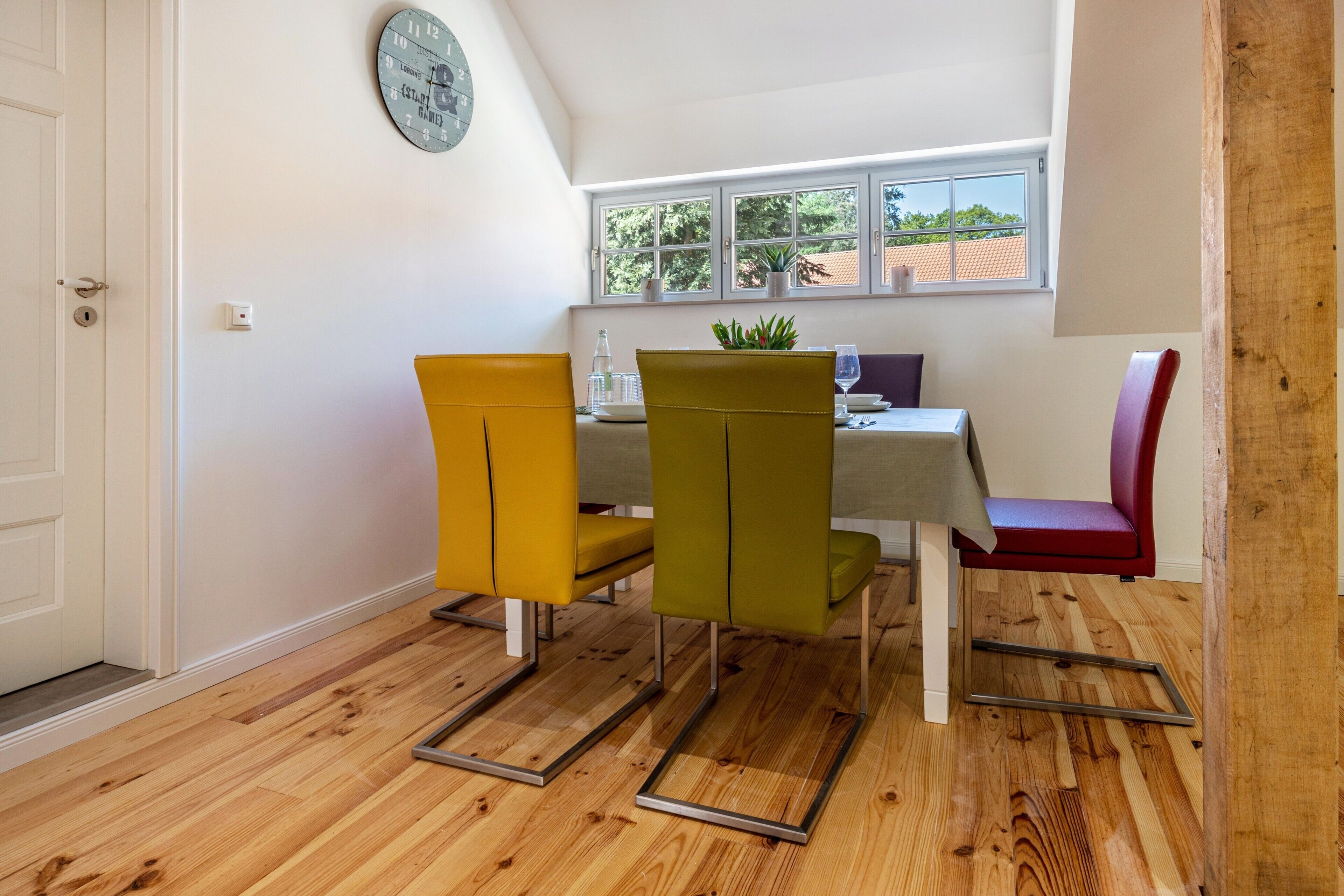 A dining area with a table, chairs, and a window with a view.