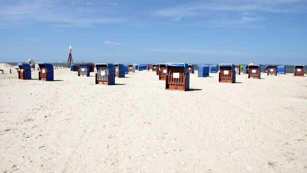A beach with rows of blue and brown beach huts. - Apartment 'Ferienhaus Gerda Wohnung 2' with Private Terrace, Private Garden and Wi-Fi (Ochtersum)