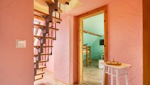 A room with a wooden staircase, a white table, and a green wall. - Holiday Home 'Ferienhaus Fichtelberg' with Mountain View, Private Terrace and Wi-Fi (Oberwiesenthal)