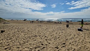 A beach with footprints, tents, and a clear sky. - Luxury Apartment St Lucia 43 On the Bridge (Saint Lucia)