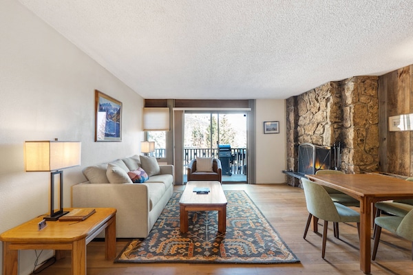 The living area offers a pull-out sofa bed for additional sleeping space, a dining table for 4, a wood burning fireplace and flat screen TV.