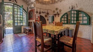 A dining area with a table set for four, surrounded by wooden chairs with woven seats.