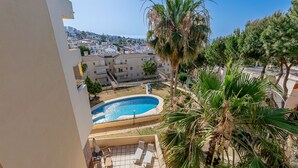 A pool area with lounge chairs and a view of a coastal town. - Refugio de Riviera 2 bed apt with sea view (Mijas Costa)