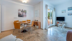 A modern living room with a dining area, a TV, and a balcony with a view. - Refugio de Riviera 2 bed apt with sea view (Mijas Costa)