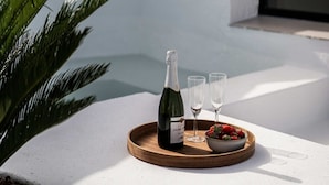 A bottle of champagne on a tray with two glasses and a bowl of strawberries on a white balcony. - Lomas del Marbella | Puente Romano Penthouse (Marbella)