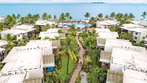 A resort with multiple buildings, a central pool, and palm trees. - Fiji - Whyndham- Beachfront Resort- Denarau - 1 BR (Denaru Isand)