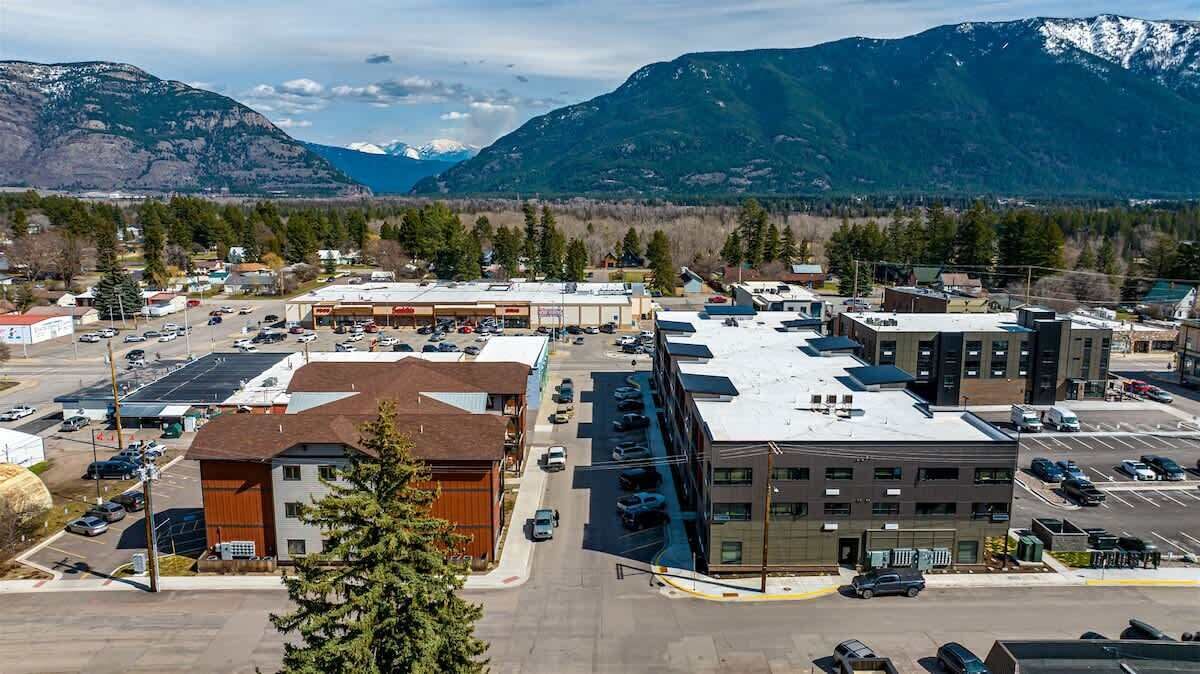 A commercial area with buildings, parking lots, and a mountainous backdrop.