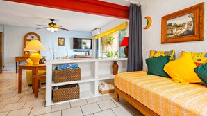 A bedroom with a bed, a desk, a chair, a lamp, a television, and a window with a view of a street. - Sofia's Casa Del Sol, in Loma Del Mar Condominiums 1BD Condo for rent in Old Tow (Puerto Vallarta)