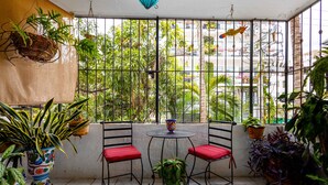 A balcony with two chairs, a small table, and various potted plants. - Sofia's Casa Del Sol, in Loma Del Mar Condominiums 1BD Condo for rent in Old Tow (Puerto Vallarta)