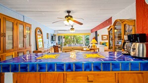 A kitchen with wooden cabinets, a blue tiled island, and a ceiling fan. - Sofia's Casa Del Sol, in Loma Del Mar Condominiums 1BD Condo for rent in Old Tow (Puerto Vallarta)