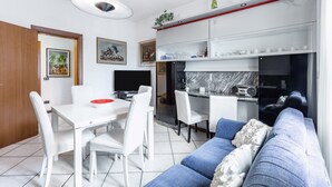 Une cuisine moderne avec des meubles blancs, un pare-feu en marbre et une radio intégrée.