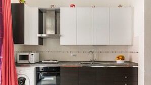 A modern kitchen with a microwave, oven, and sink. - Essenza Holiday House (Florencia)