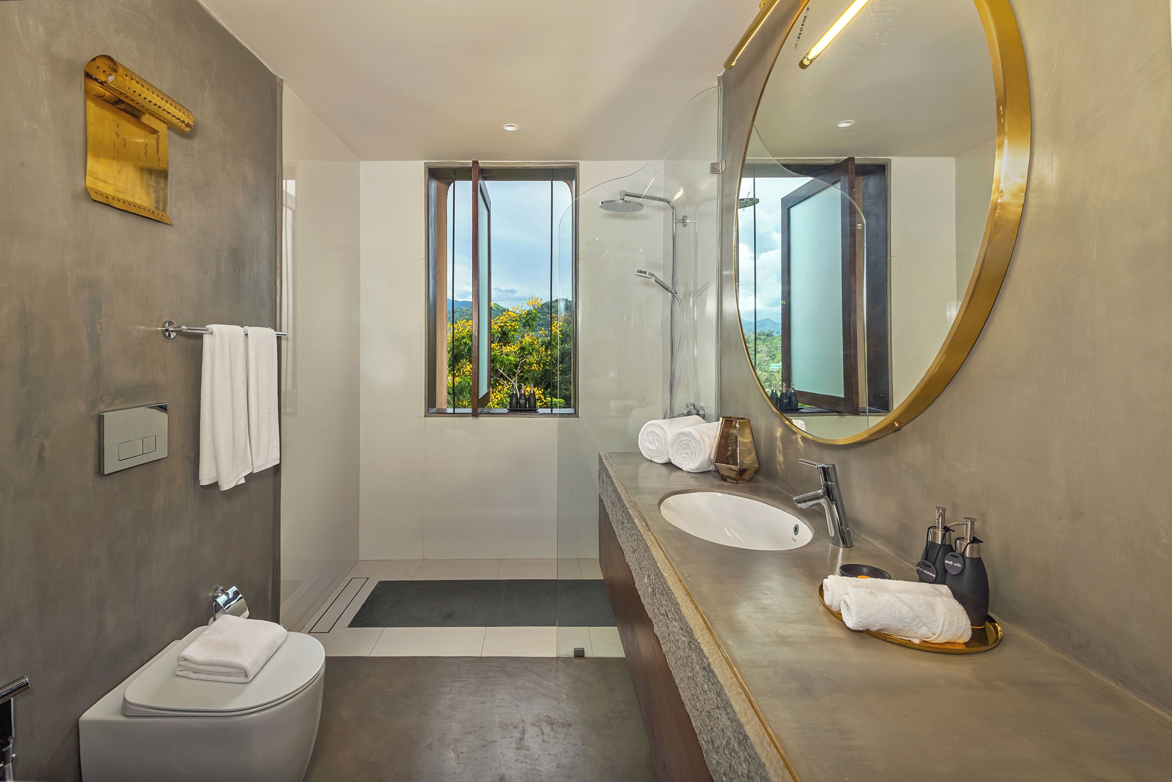 Ein modernes Badezimmer mit großem Spiegel, Toilette, Waschbecken und Dusche.