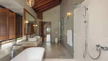 Un baño moderno con una bañera grande, dos lavamanos, una ducha a pie y techo de madera.